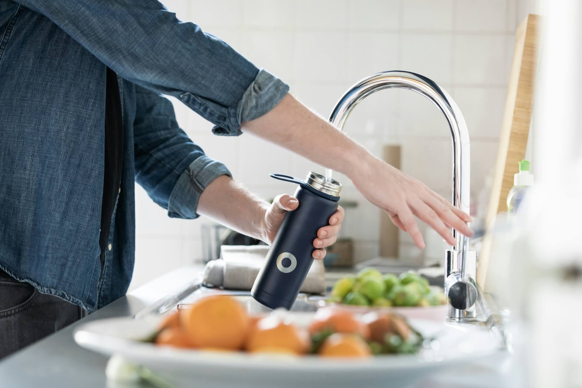 A person filling up a reusable bottle